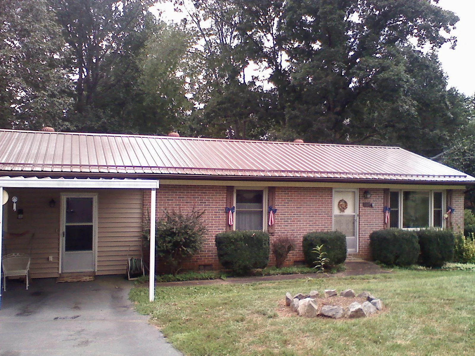 Bronze metal roof and carport on a brick ranch home — Roof Repair work by our crew in Franklin